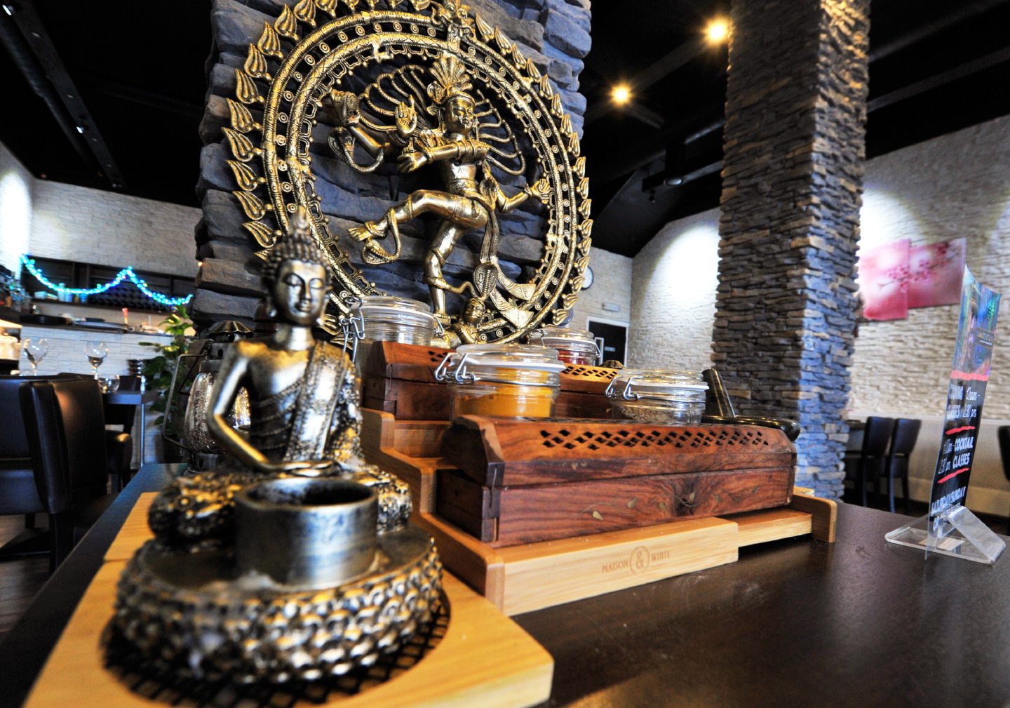 A buddha statue sitting on a table in Namaste Delhi in Aberdeen