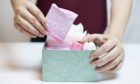 Closeup photo of young woman picking sanitary pad out of green box; Shutterstock ID 528070513; Purchase Order: My Weekly - December 19; Job: Dr Sarah Jarvis