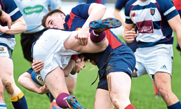 The annual Boxing day rugby game between Aberdeen Select (blue) and Aberdeen Exiles (hoops). Select's Sean Mills gets to grips with Exiles' Stuart Niven. Picture by Chris Sumner