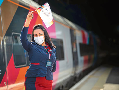 Avanti West Coast staff wave off the UK's first fully wrapped Pride train.