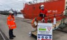 Stella Maris volunteers deliver goods to crew members on Sister Rosario support vessel.