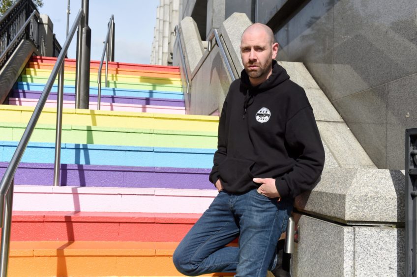 Wray Thomson of Man Chat on the rainbow steps outside the Trinity Centre 