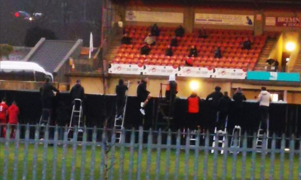 Deveronvale fans on stepladders trying to watch their team's Scottish Cup tie.