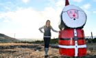 Jenna Ross with the Christmas silage bale Santa in Tarland
