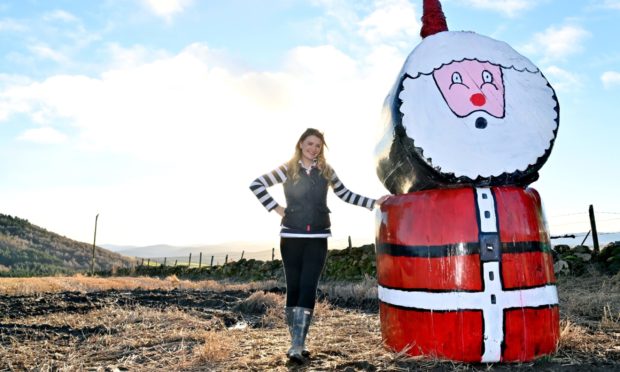 Jenna Ross with the Christmas silage bale Santa in Tarland