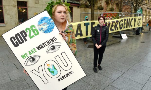 Climate campaigners May Armstrong of Lairg (left) and Lily Henderson of Inverness as they protest in Falcon Square on Saturday.
