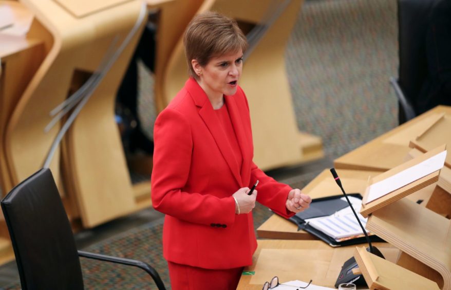 First Minister Nicola Sturgeon giving an update on Covid restrictions in the Scottish Parliament, Edinburgh. PA Photo. Picture date: Tuesday December 22, 2020. See PA story SCOTLAND Coronavirus. Photo credit should read: Russell Cheyne/PA Wire