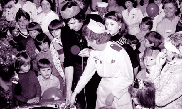 Radio 1 DJ Ed Stewart cuts a special Christmas cake with the help of Sister M Glennie after recording a radio programme in Ward 3 of the Royal Aberdeen Children's Hospital in 1978.