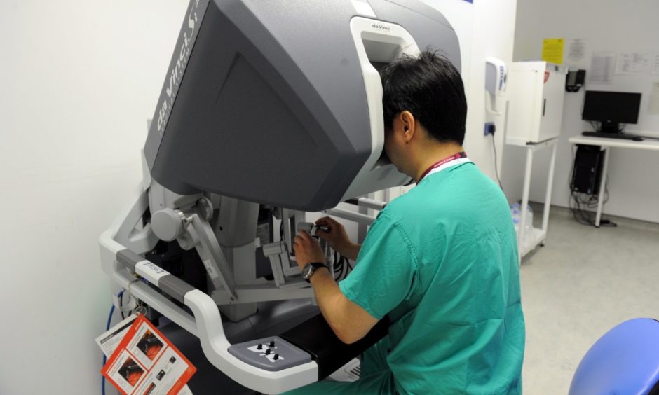 Dr Thomas Lam at the control of the robotic surgical console in the urology theatre at ARI, 2017.