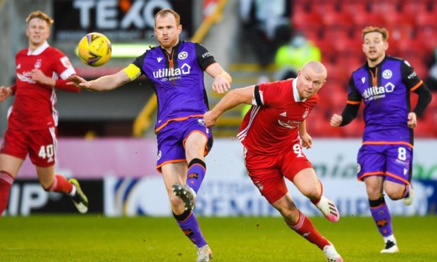 Dundee United captain Mark Reynolds and Aberdeen's Curtis Main in action.