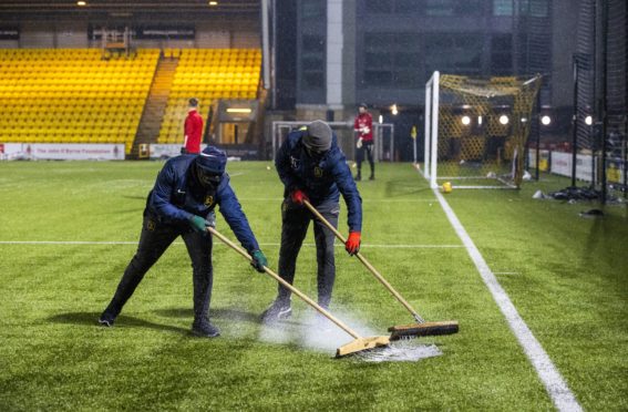 Ground staff sweep rain off the pitch during a Scottish Premiership match between Livingston and Aberdeen at the Tony Macaroni Arena.