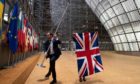 Staff members arrive to remove the United Kingdom's flag from the European Council building in Brussels on Brexit Day.