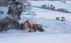 A council tractor cutting back bushes at the side of the untreated road in Belnagarrow, Craigellachie. More than four inches of snow had fallen.