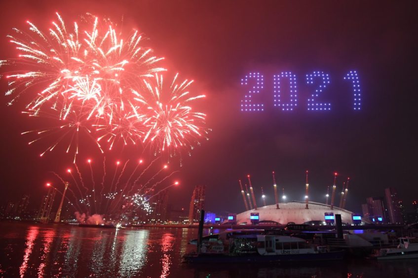Fireworks and drones illuminate the night sky over London as they form a light display as London's normal New Year's Eve fireworks display was cancelled due to the coronavirus pandemic. PA Photo. Picture date: Thursday December 31, 2020. Photo credit should read: Victoria Jones/PA Wire