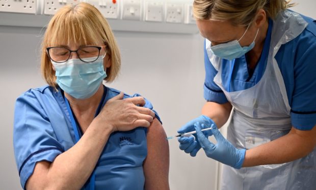 NHS worker Grace Thomson receives the first of two Pfizer/BioNTech Covid-19 jabs, administered by Paula McMahon.