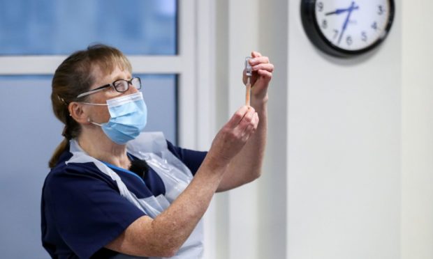 A healthcare worker holds a vial of the Oxford/AstraZeneca coronavirus vaccine at Pentlands Medical Centre in Edinburgh.