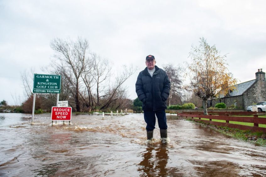 David Mackay standing in flooded road in Garmouth