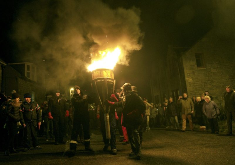 The Clavie is led through the streets of Burghead.