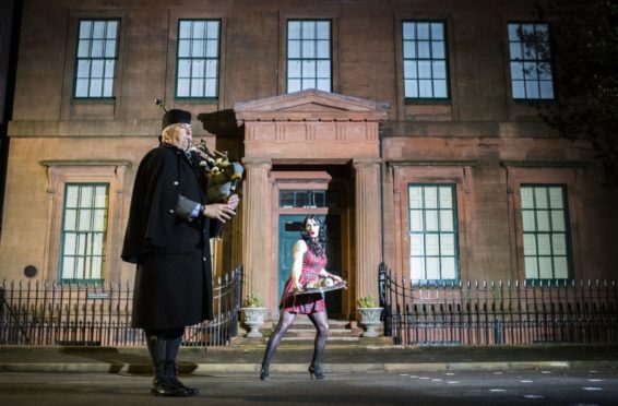 Piper Craig Burn and drag artist Justin Hyslop, aka Tattie Von Haggis, pipe the haggis through Dumfries town centre, for the launch of Janey Godley's Big Burns Supper 2021. The free digital gathering, being held on Burns Night on January 25, will be hosted by Scottish comic Jane Godley and feature artists including KT Tunstall, Dougie Maclean, Donovan, Tide Lines and Skerryvore. PA Photo. Picture date: Tuesday January 12, 2021. See PA story SOCIAL Burns. Photo credit should read: Jane Barlow/PA Wire