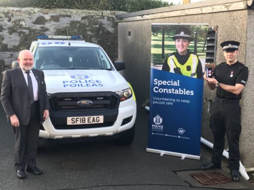 SPC Euan Anderson with his long-service medal, presneted to him by Shetland councillor Alastair Cooper