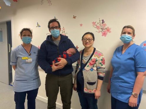 Kieran and Kun Gullett and baby  January 1, 2021 with NHS staff at Aberdeen Maternity Hospital.