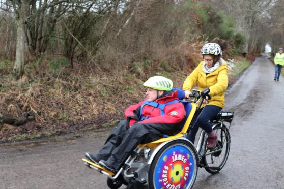 Angelman James Murray from Kirkhill on his new electric duet bike, pedalled by his mum Kathleen