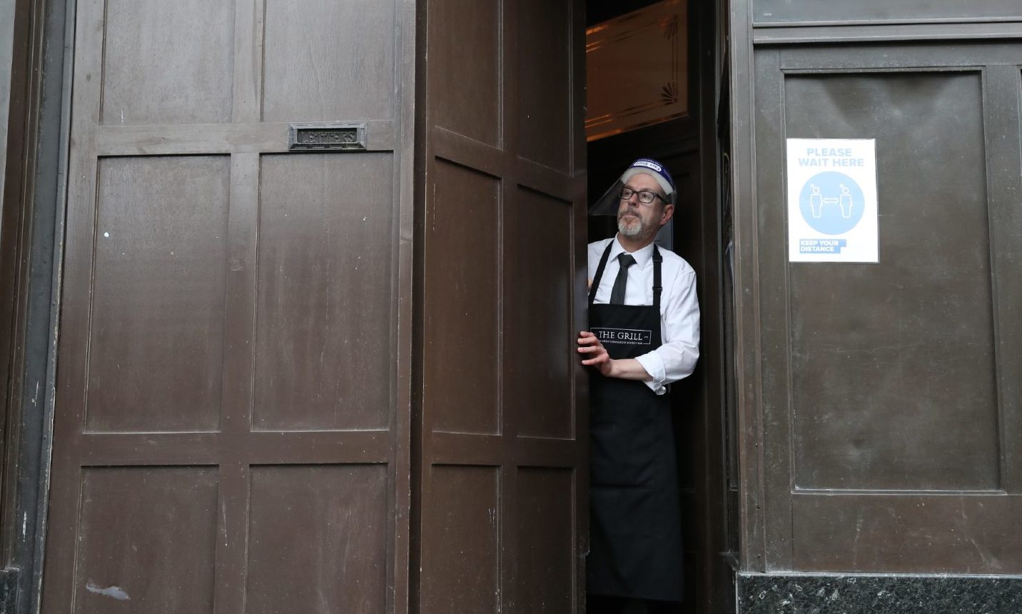 Keith McKenzie closes the door of The Grill in Aberdeen as lockdown restrictions are imposed. 