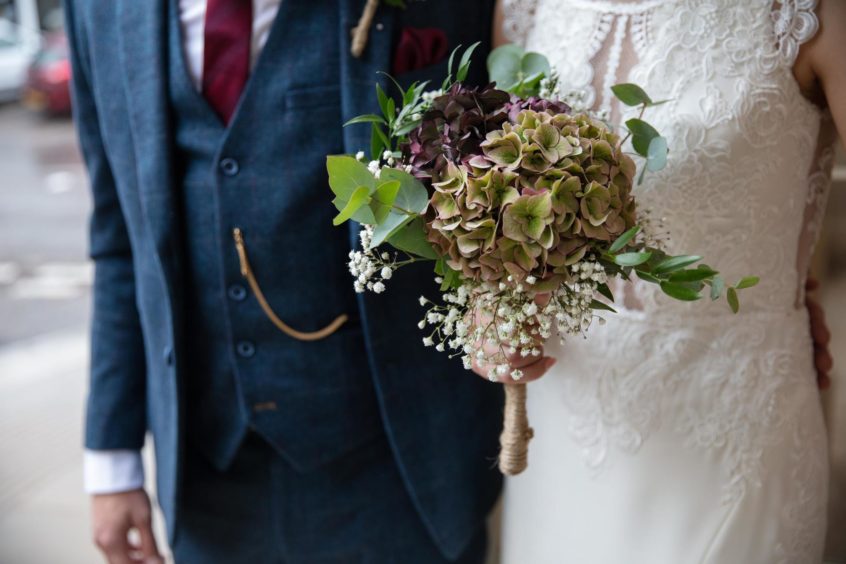 bride holding flowers and groom