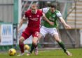 Dylan McGeouch holds off Jamie Murphy of Hibs.