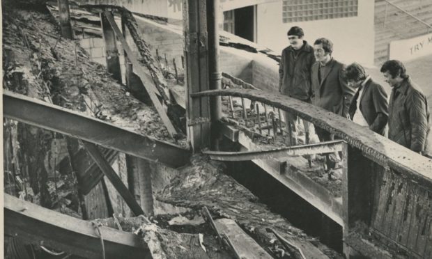 The Aberdeen players assess the damage when they returned to the ground after the blaze.