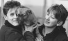 Kennel maids Julie Cockrill (left) and Marie Simpson hug Alsatian pup Peggoty at Mrs Murrays Cat and Dog Home in 1988.