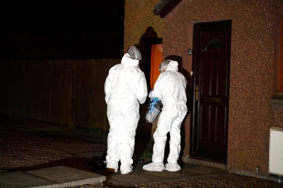 Forensic officers examined the scene after the woman was found. Picture: Kenny Elrick