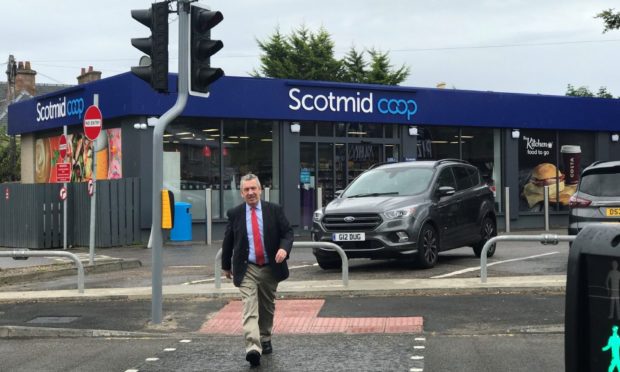 MSP David Stewart pictured using the newly installed puffin crossing on the A82 on Glenurquhart Road at Smith Avenue.