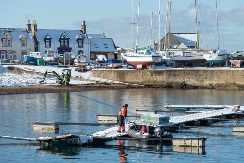 Contractors have worked in heavy snow showers at Findochty Harbour.