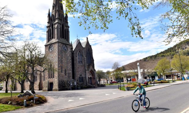 A cyclist passes Glenmuick Church in Ballater, where a planning application to 'transform' the village has been lodged.