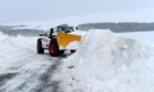Deep snow is removed from the Nethy Bridge to Tomintoul road at Corriechullie, Nethy Bridge, amid a weather warning.