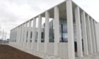 The concrete and glass front elevation of Inverness justice centre rises into a grey sky