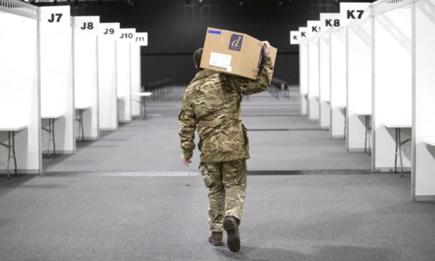 A member of the Royal Scots Dragoon Guard carries in supplies for the mass coronavirus vaccination centre at P&J Live, Aberdeen.