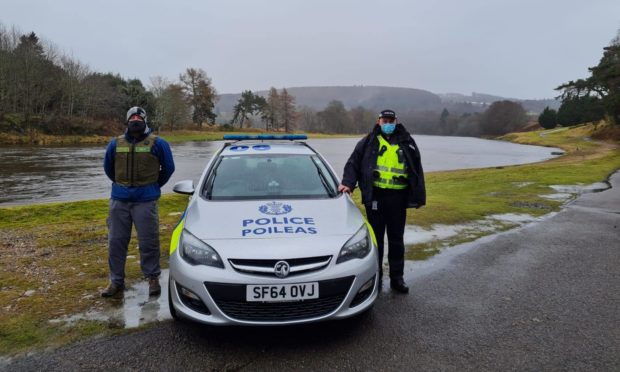 A Dee District Salmon Fishery Board fisheries officer, alongside a Police Scotland officer, at the banks of the River Dee.