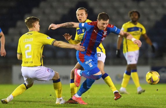 Shane Sutherland of Inverness (centre) looks to break free from Michael Ledger (L) and Aidan Nesbitt of Morton.