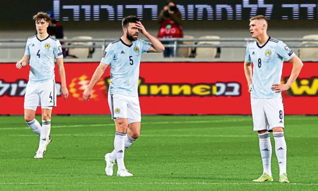 (Left to right) Scotland's Jack Hendry, Grant Hanley and Scott McTominay after conceding the opening goal during the World Cup qualifier between Israel and Scotland at Bloomfield Stadium, on March 28, 2021, in Tel Aviv, Israel.