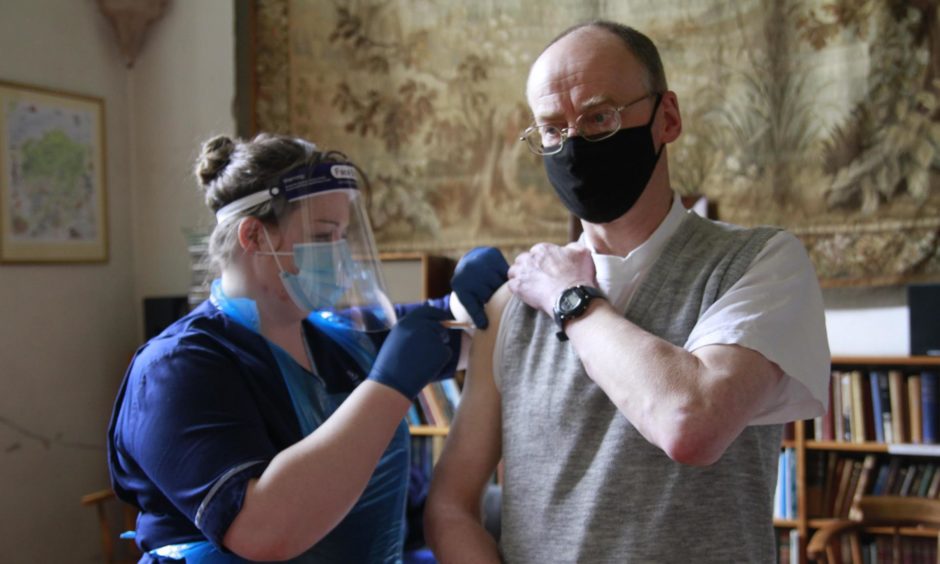 Father Benedict Hardy, the Abbey's Prior, receiving his Covid-19 injection.