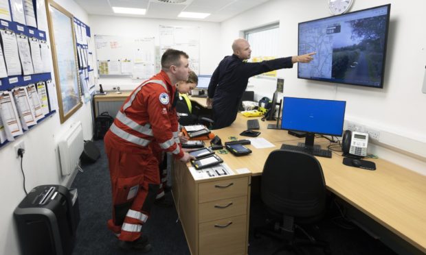 Helimed 79 pilot Pete Winn leads a crew briefing with paramedics Rich Forte and Laura McAllister before departing Aberdeen for a job