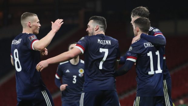 Scotland's John McGinn (centre) celebrates with Scott McTominay (left) after scoring their side's second goal of the game during the FIFA 2022 World Cup qualifying match at Hampden Park, Glasgow. Picture date: Thursday March 25, 2021. PA Photo. See PA story SOCCER Scotland. Photo credit should read: Jane Barlow/PA Wire.

RESTRICTIONS: Use subject to restrictions. Editorial use only. Commercial use only with prior written consent of the Scottish FA. Call +44 (0)1158 447447 for further information.