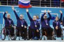From left, Great Britain's Angie Malone, Jim Gault, Bob McPherson, Gregor Ewan, and Aileen Neilson celebrate after wining bronze medals after the wheelchair curling match between Great Britain and China at the 2014 Winter Paralympics in Sochi, Russia.