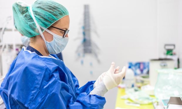 Nurse putting on PPE