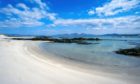 Empty white sandy beach near the Strand on the Hebridean Island of Colonsay in Summer with the Island and Paps of Jura on the horizon.