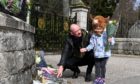 Flower tributes left at the Balmoral Castle front gate in memory of the late Duke of Edinburgh, Prince Philip.
Pictured are Steve Mitchell and daughter Constance, 4.