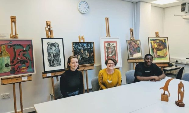 Dr Kate Cowcher (centre) and St Andrews alumni and project research assistants, Meredith Loper and Elikem Logan, with modern African artworks at Lochgilphead High School, March 2019.