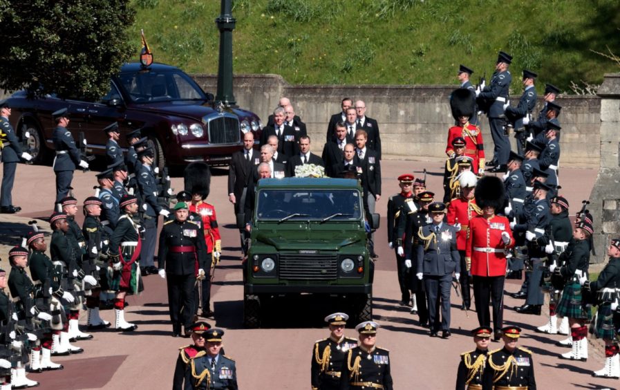 The Duke of Edinburgh's coffin, covered with his Personal Standard, is carried on the purpose built Land Rover Defender followed by the Princess Royal, the Prince of Wales, the Duke of York, the Earl of Wessex, the Duke of Cambridge, Peter Phillips, the Duke of Sussex, the Earl of Snowdon and Vice Admiral Sir Timothy Laurence outside St George's Chapel, Windsor Castle, Berkshire, before the funeral of the Duke of Edinburgh. Picture date: Saturday April 17, 2021. PA Photo. See PA story FUNERAL Philip. Photo credit should read: Hannah McKay/PA Wire
